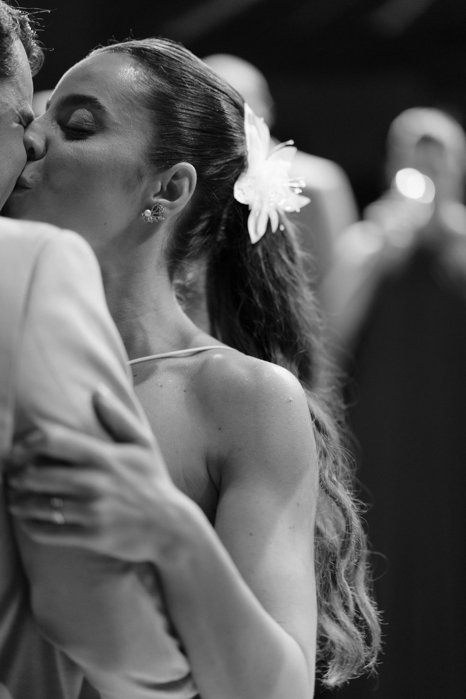 A romantic black and white photograph showing a tender kiss between two people in soft focus.