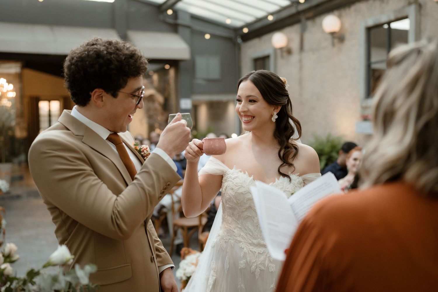 A couple shares an intimate dance moment during their wedding celebration in a rustic indoor venue.