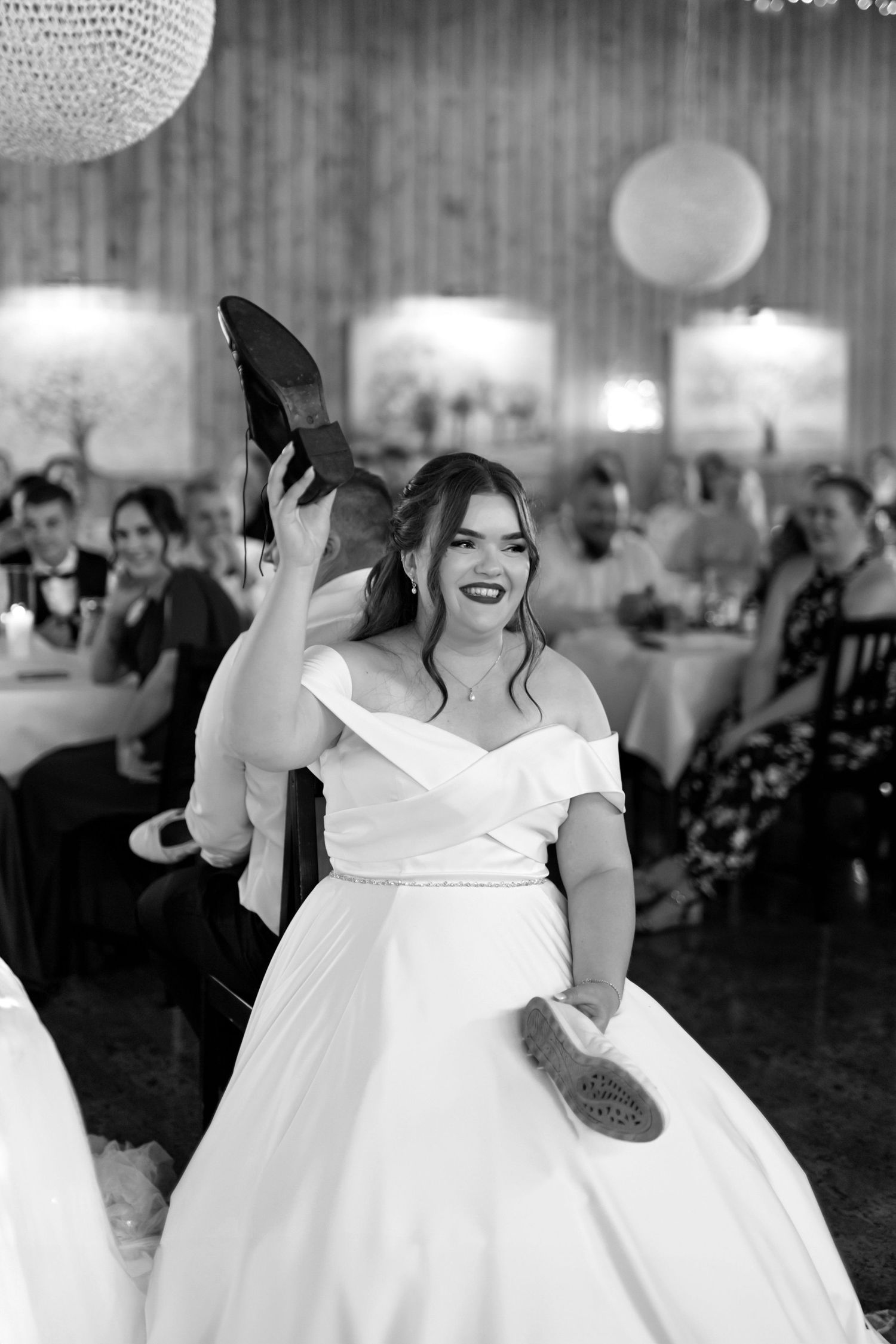 A joyful dance moment captured in black and white under crystal chandeliers.