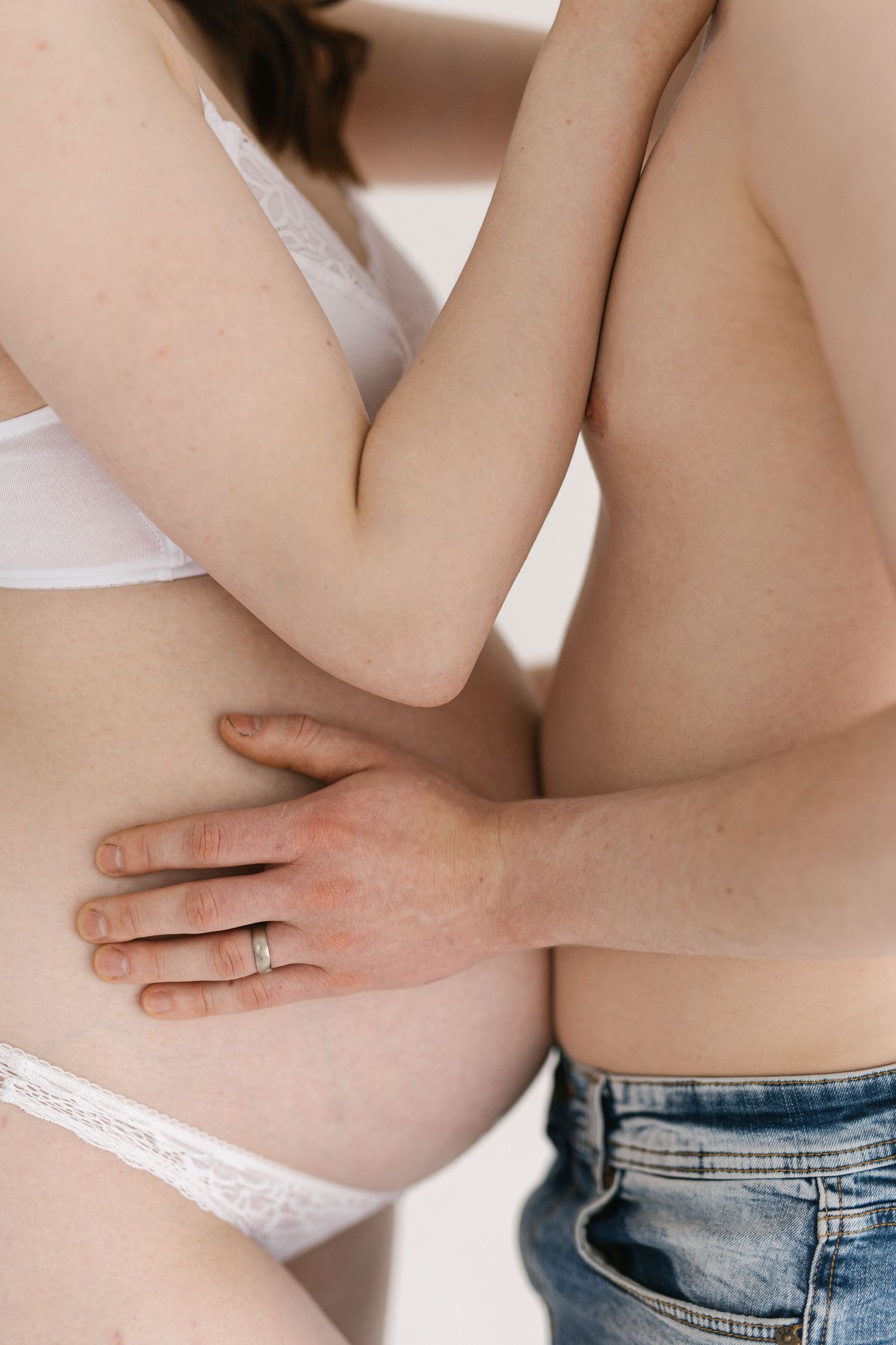 Close-up of hands gently resting on pregnant belly.