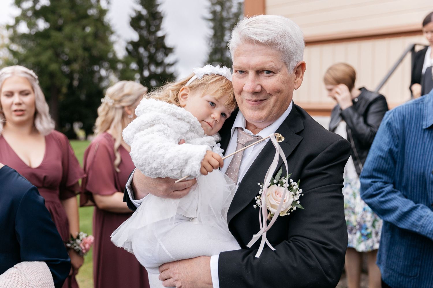 Wedding guests gather outside church during post-ceremony celebrations.