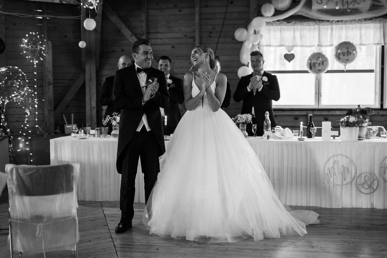 Wedding celebration in a rustic barn venue with elegant decor and lighting.