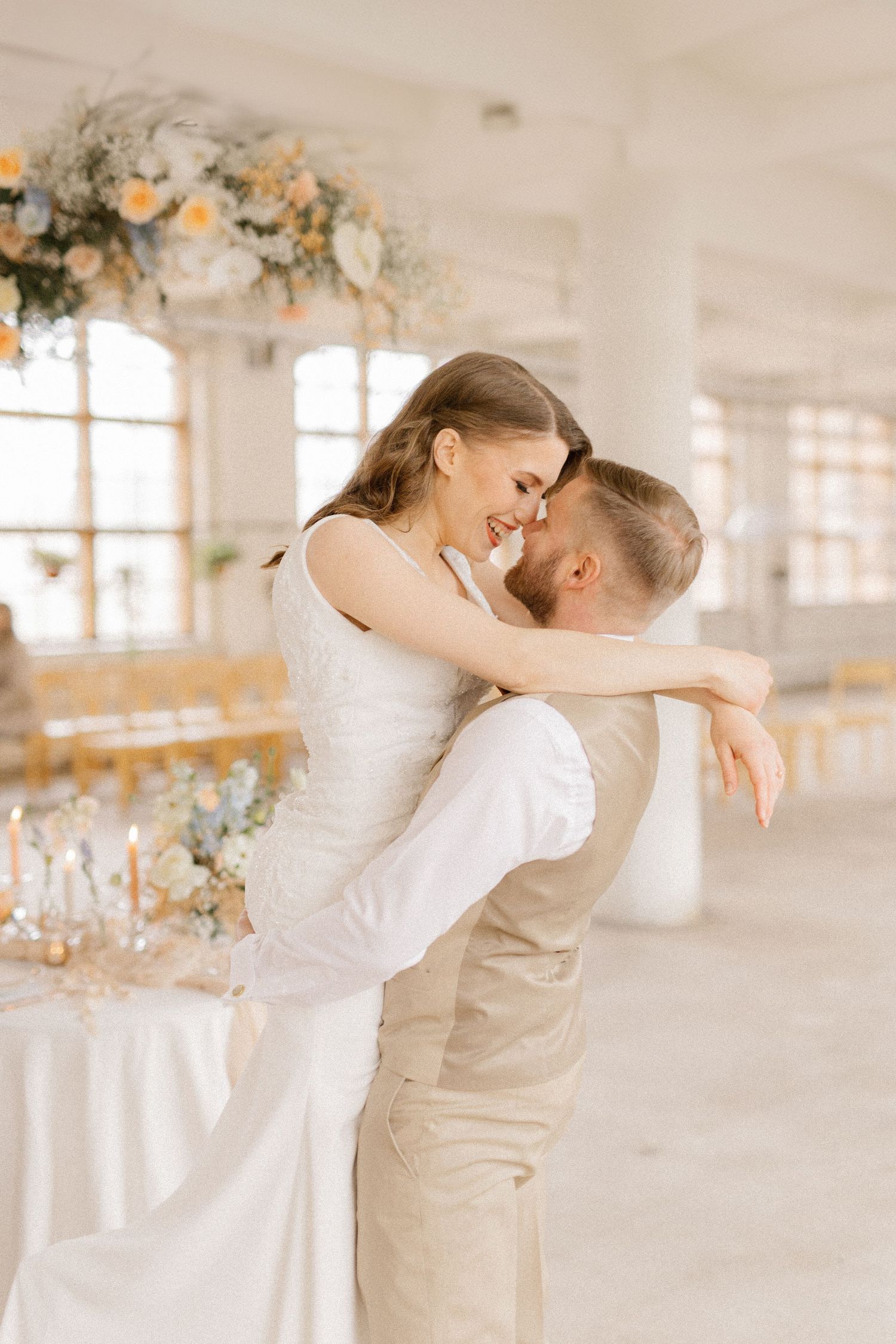 Newlywed couple sharing an intimate dance moment under floral decorations at wedding reception.
