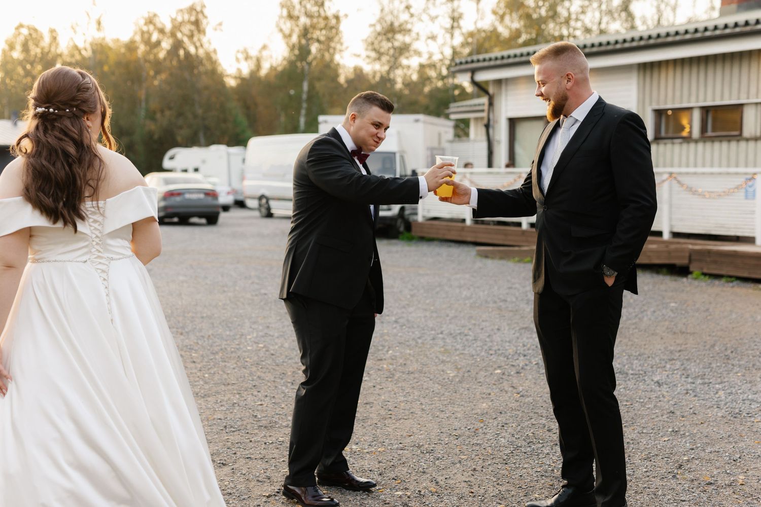 Candid moment shared between wedding party members in a casual outdoor setting.