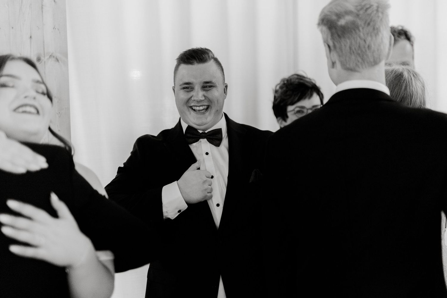 Black and white candid photograph of wedding reception celebration.