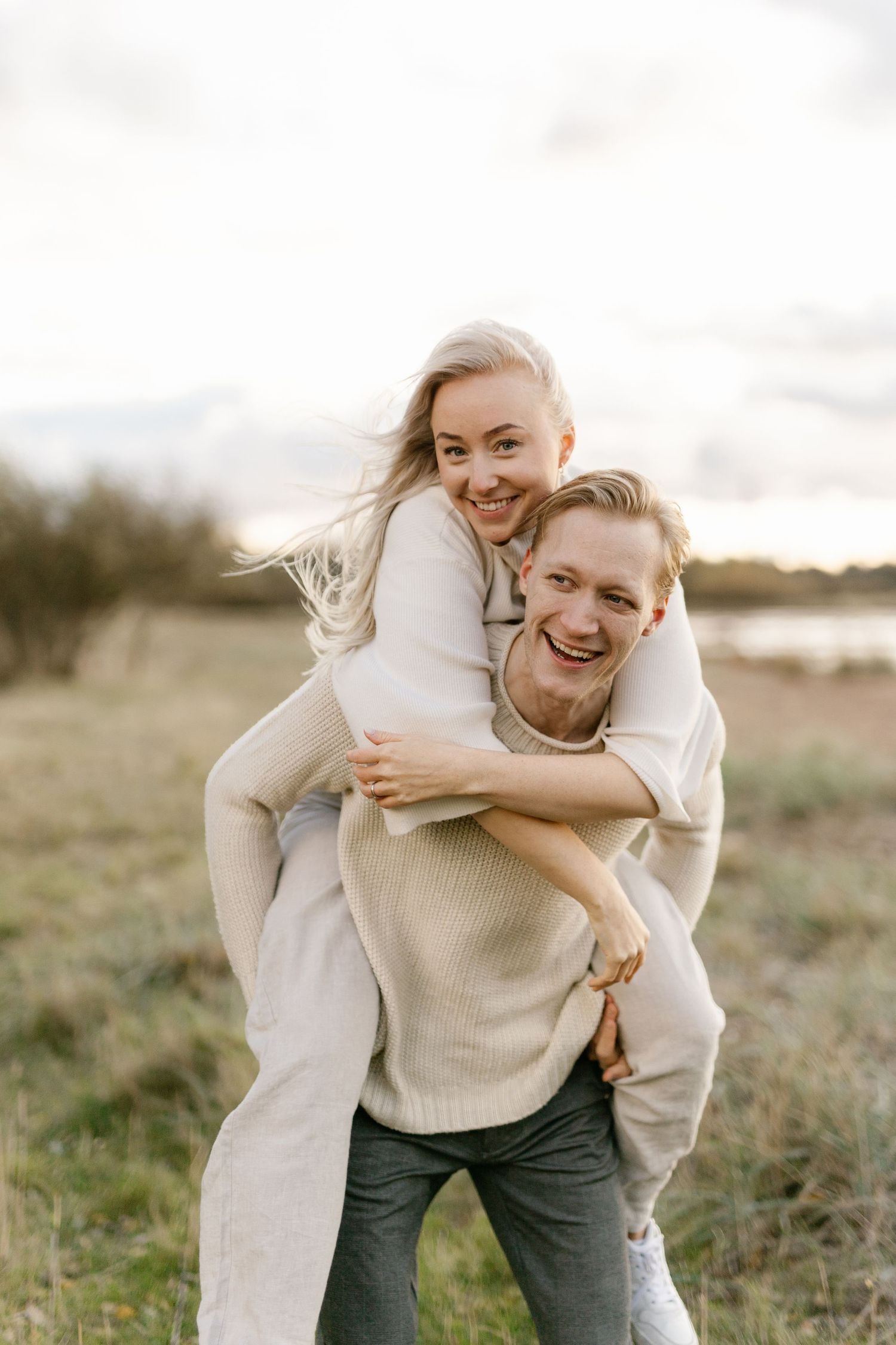 Playful piggyback ride moment captured in field during golden hour.