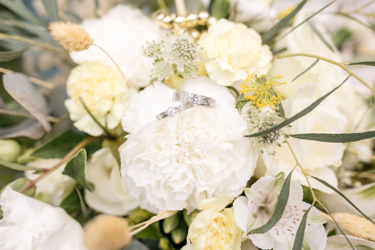An elegant wedding bouquet closeup featuring white and cream flowers with delicate details.