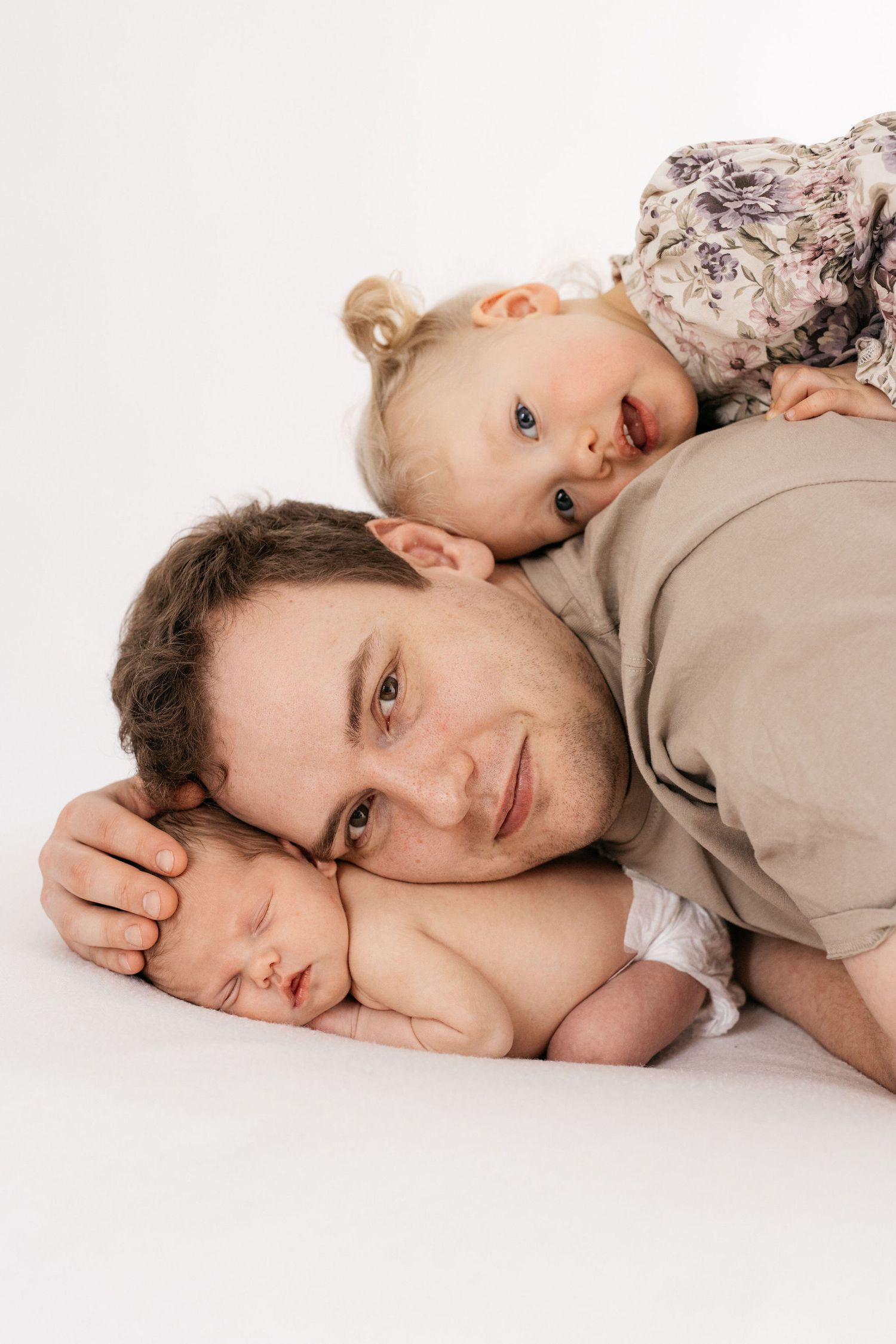 Sweet family portrait with baby laying on parent.