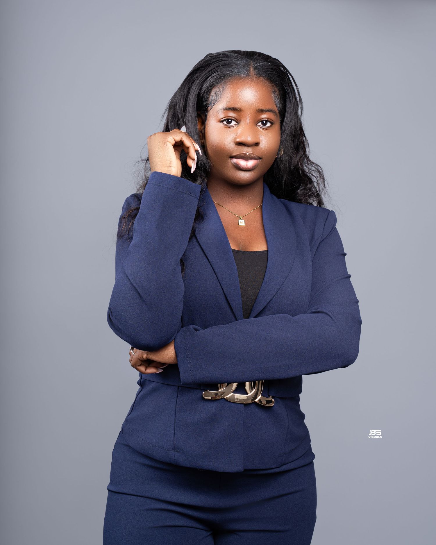 Professional woman in navy blue suit posing thoughtfully for a business portrait.