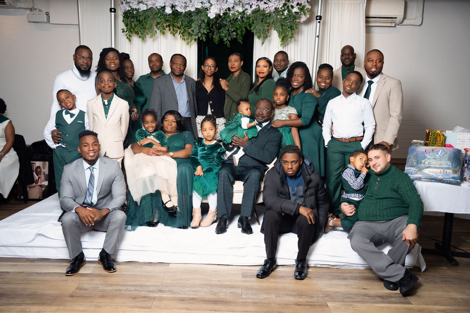 Large family group photo at formal event with green and white decor.