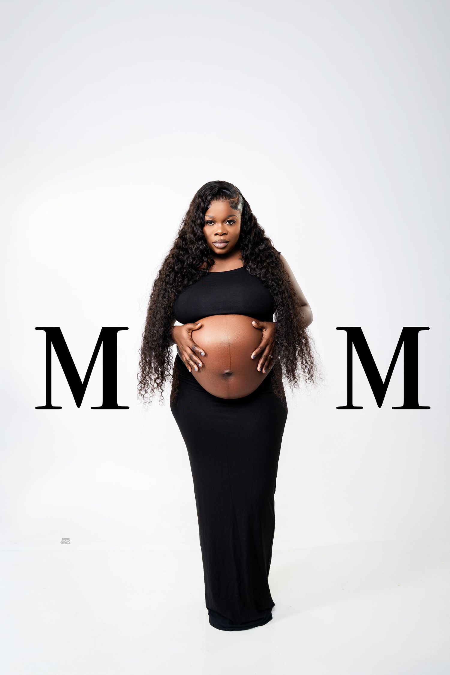 Pregnant woman in black dress cradling baby bump with bold MOM letters on white background.