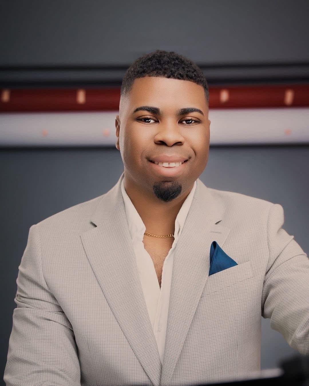 Smiling man in beige suit with blue pocket square posing for professional portrait photo.