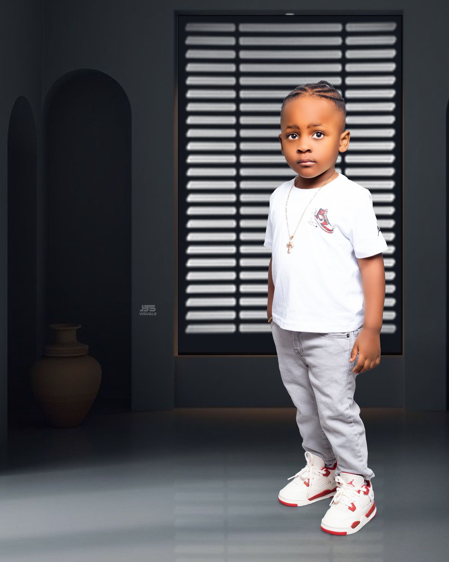 Stylish toddler boy in white tee, gray joggers, and red Jordan sneakers posing for a professional photo shoot.
