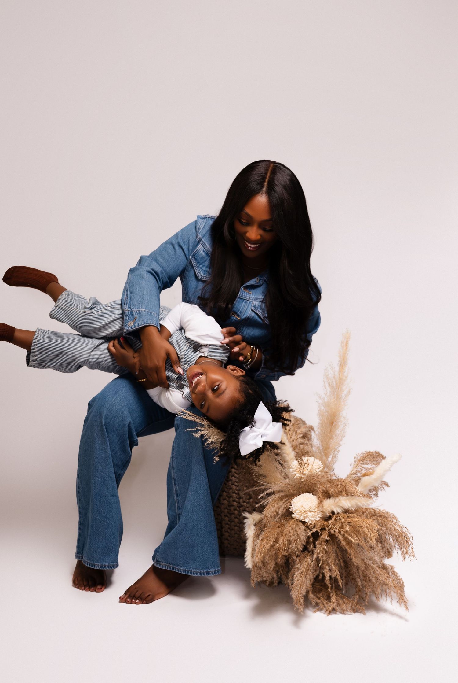 Playful lifestyle photoshoot featuring joyful poses against white background with pampas grass decor.
