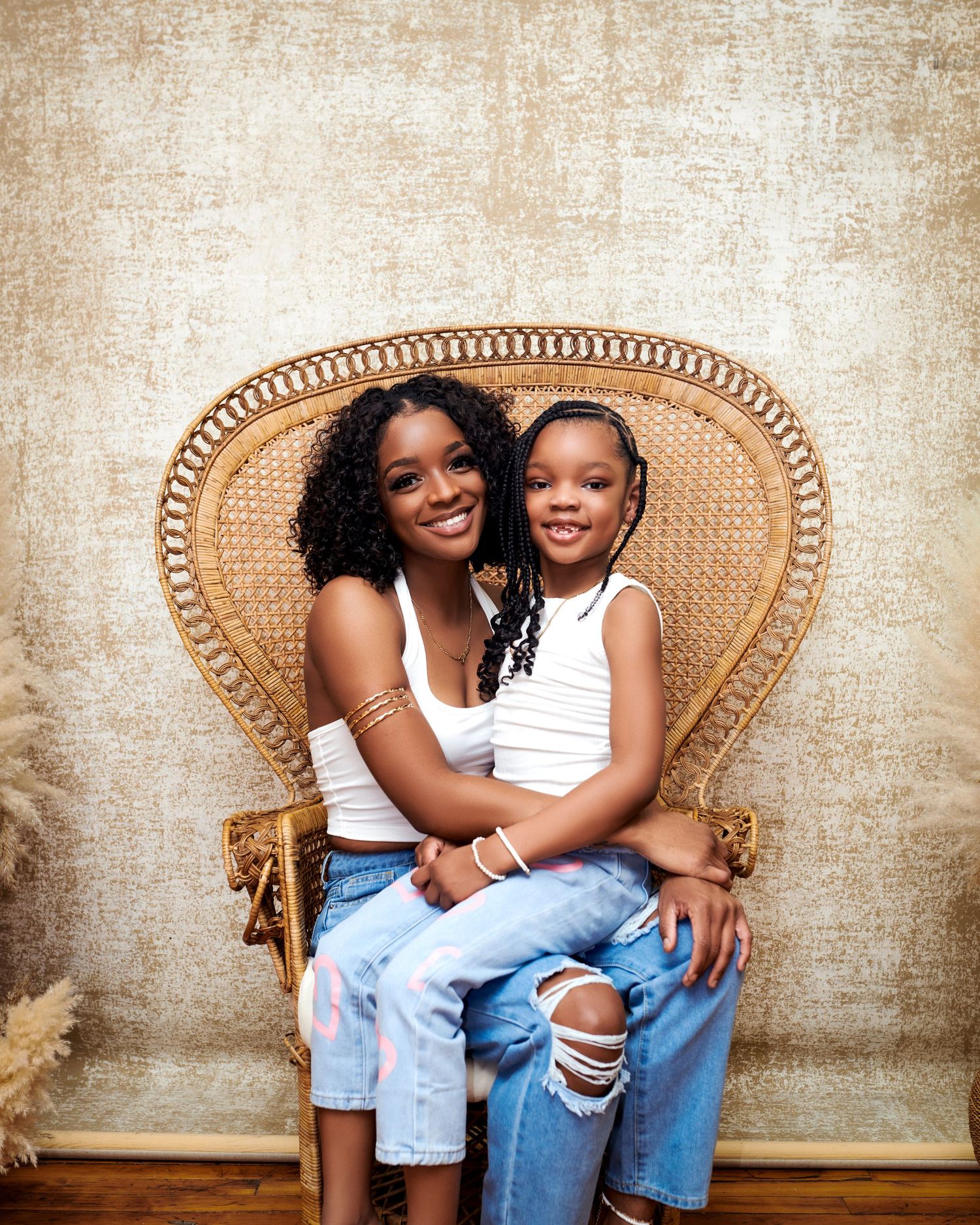 A heartwarming portrait of two people sharing a moment while seated together in a vintage peacock wicker chair.