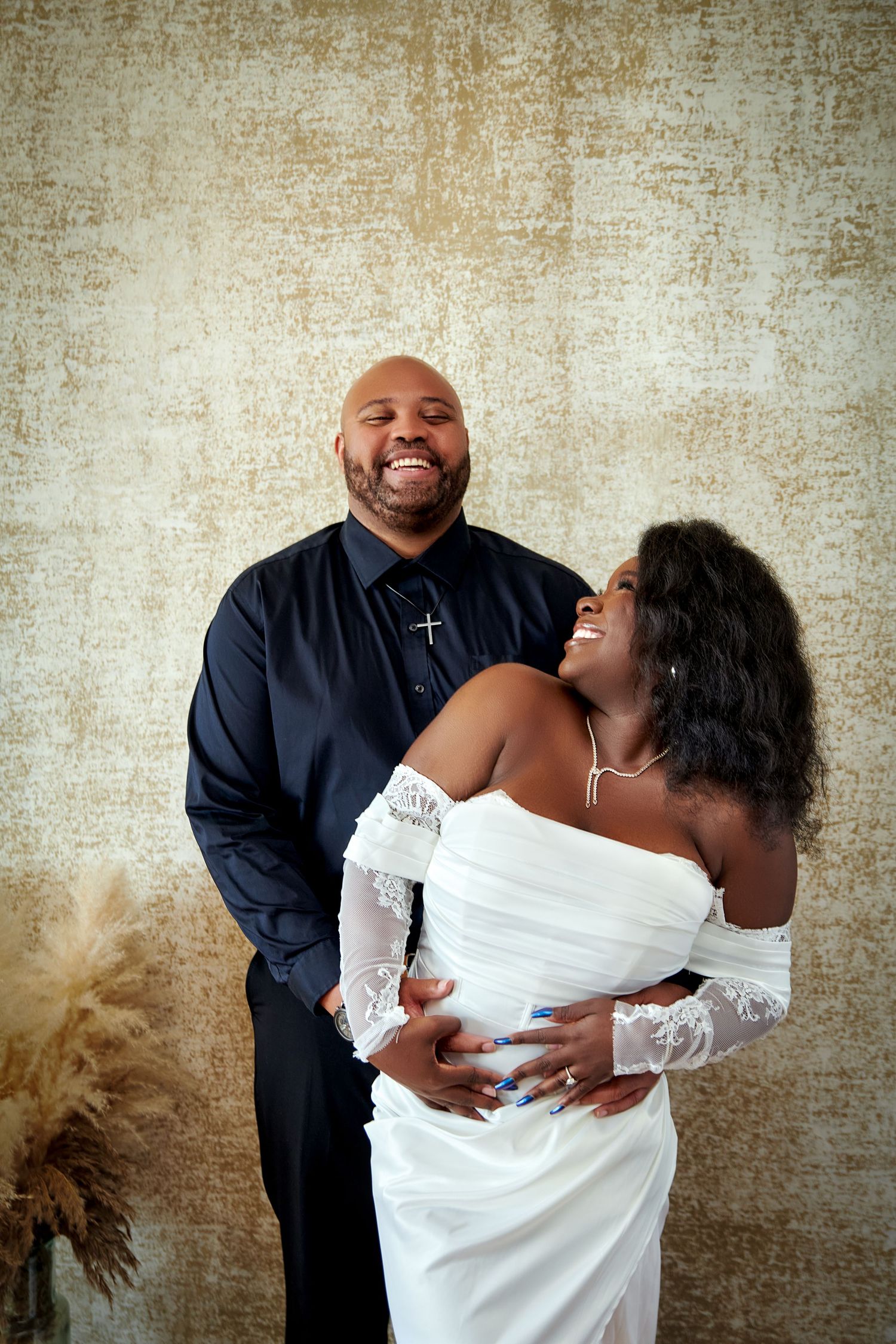 A romantic wedding photo series showing a couple in black and white attire sharing intimate moments against a textured wall.