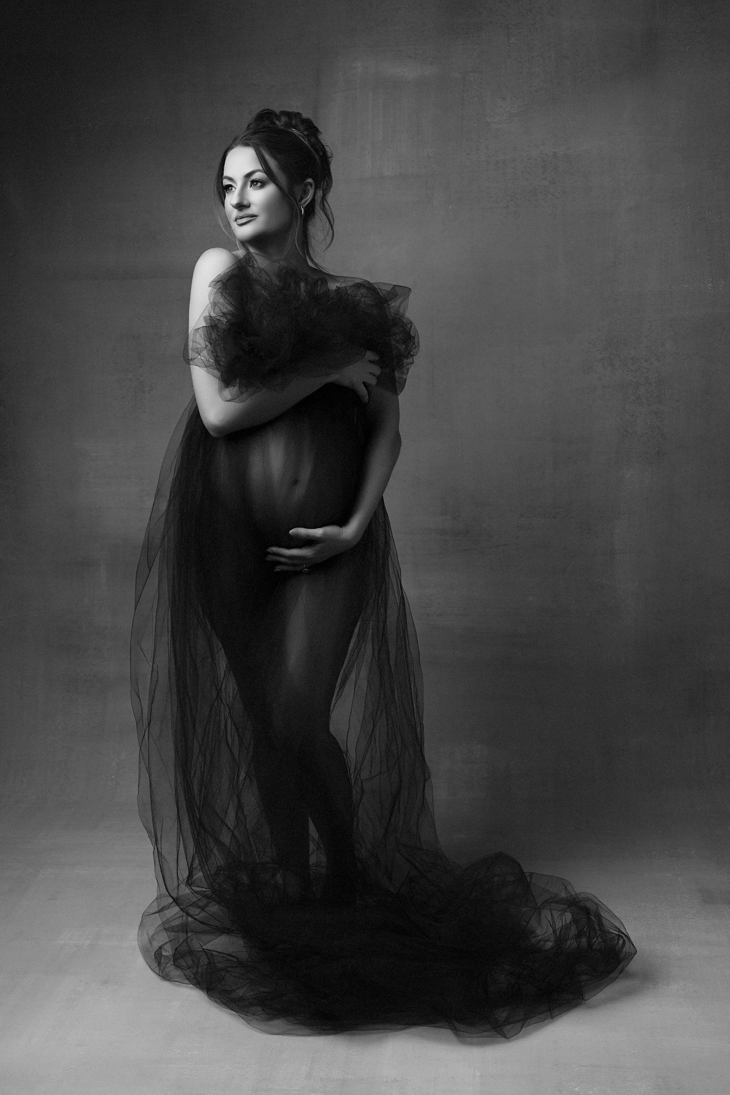 A black and white photo of a pregnant woman