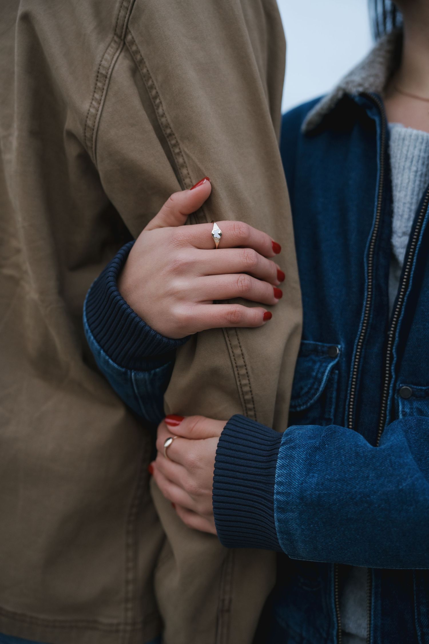 Close-up of a woman holding her partner's arm.