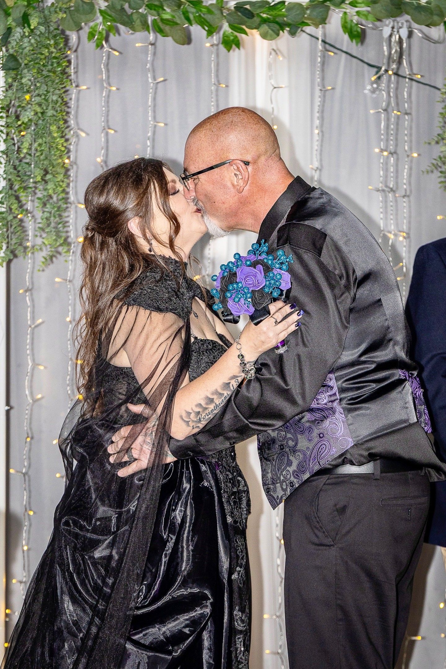 Couples dancing at an elegant event with greenery and white curtain backdrop.