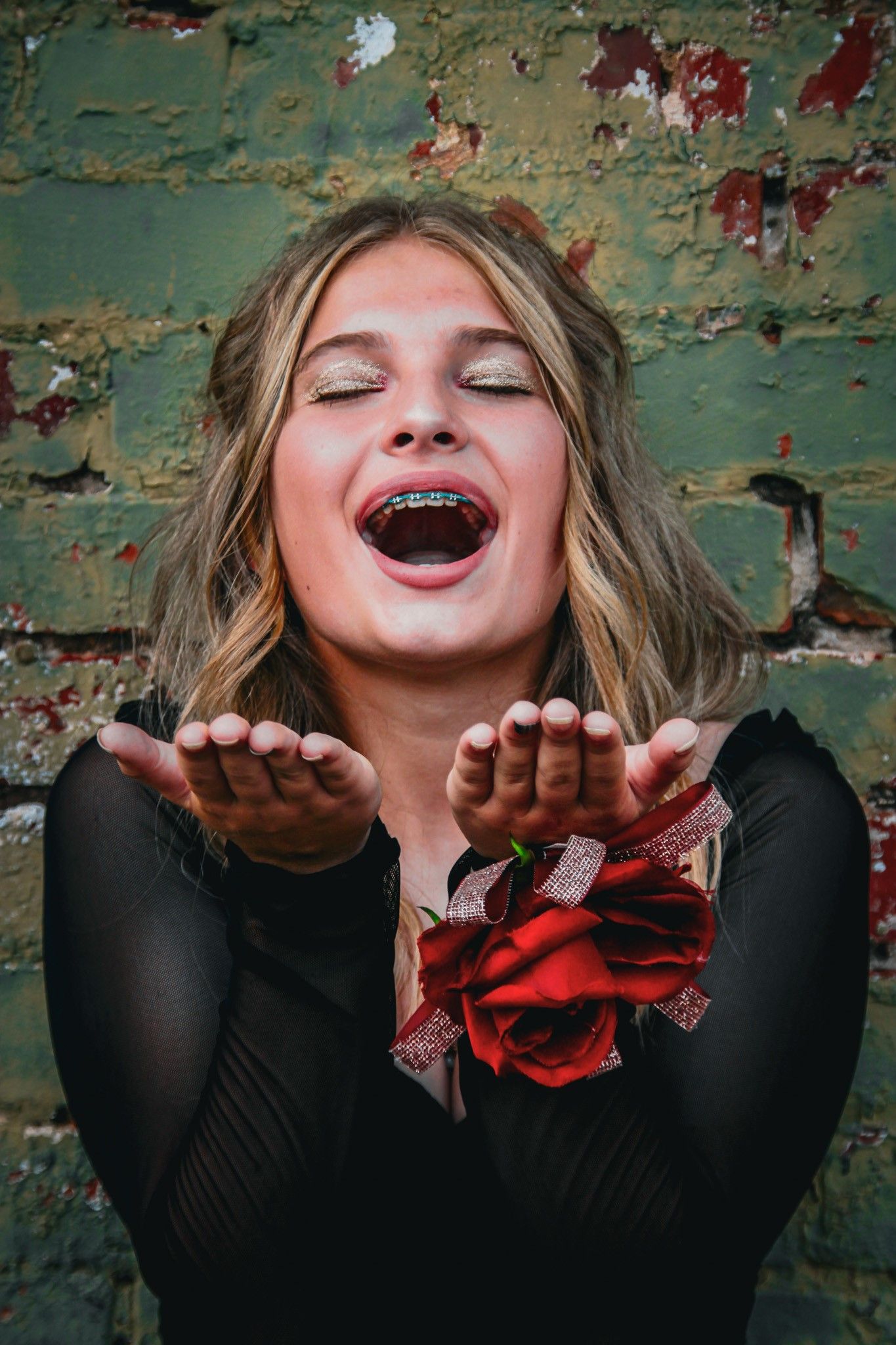 Playful portrait sequence with black top and red accents against a weathered turquoise wall.