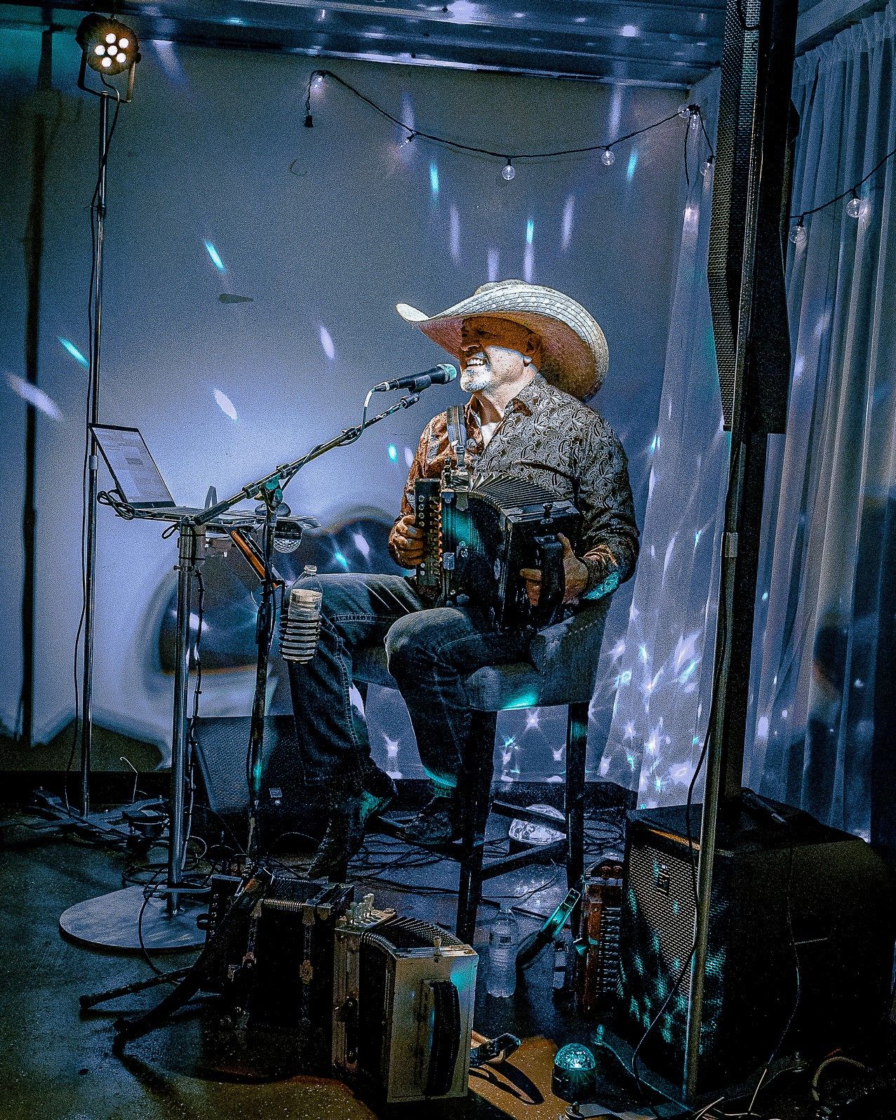 Musicians perform on stage with dramatic blue lighting effects.