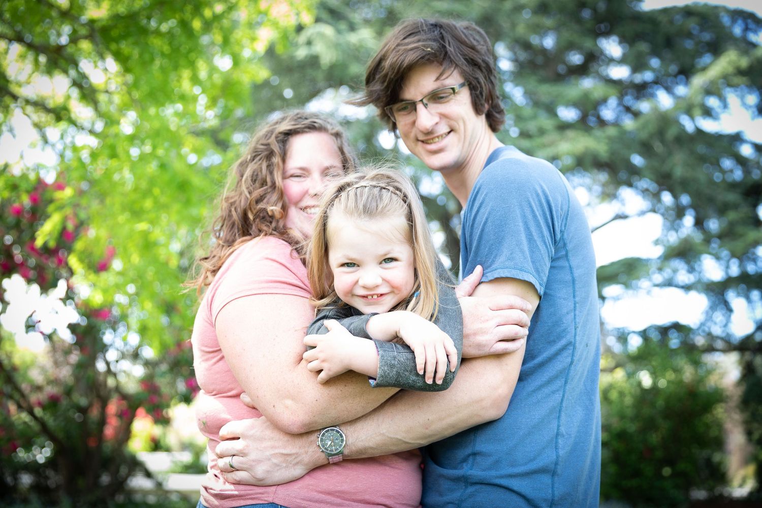A series of outdoor family portraits showing tender embraces and joyful moments against a green leafy background.