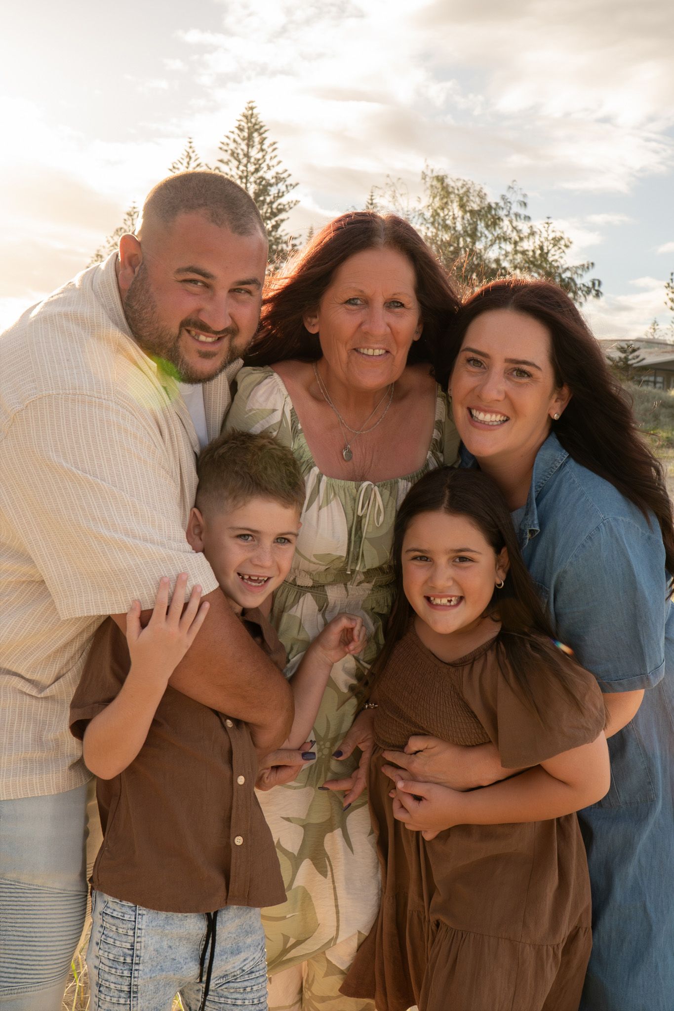 Family of four and grandma cuddling together and laughing beach golden hour - Photos by Bailey Rose Gold Coast