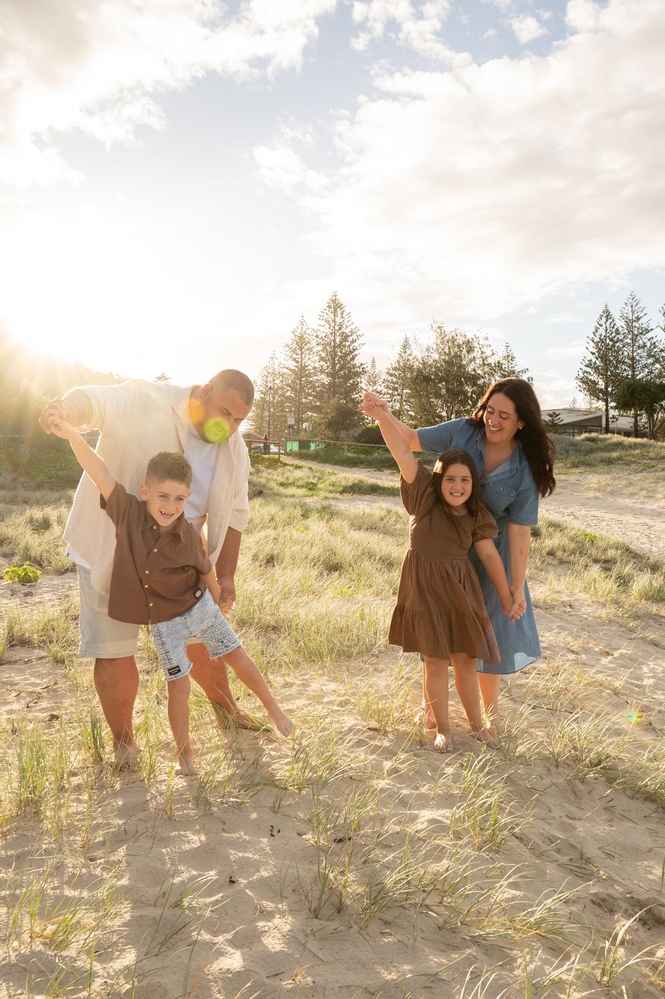 Parents and children playing aeroplanes on the beach at golden hour, unposed family sessions - Photos by Bailey Rose Gold Coast