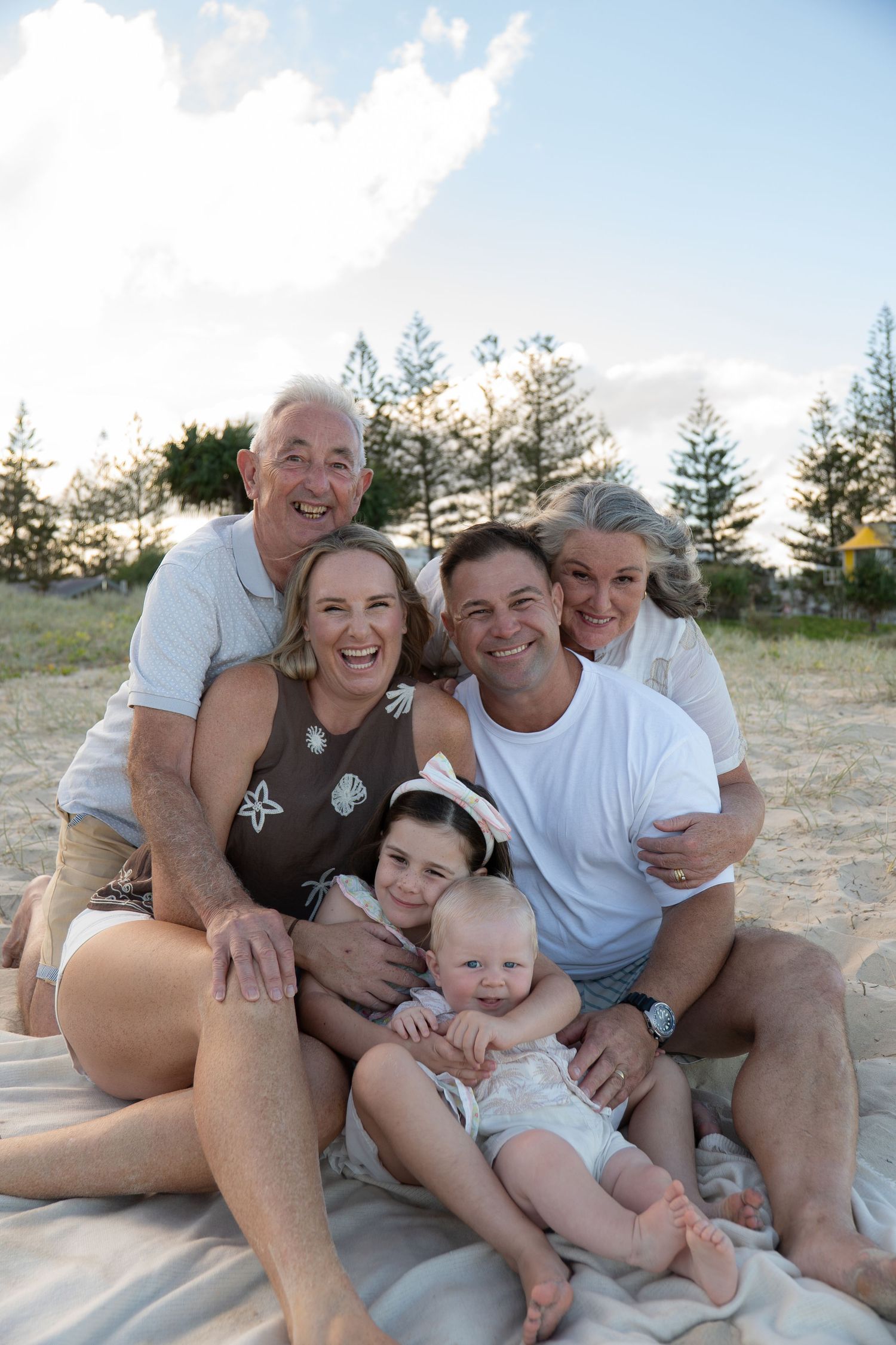 Family of four and grandma and grandpa cuddling together and laughing beach golden hour - Photos by Bailey Rose Gold Coast
