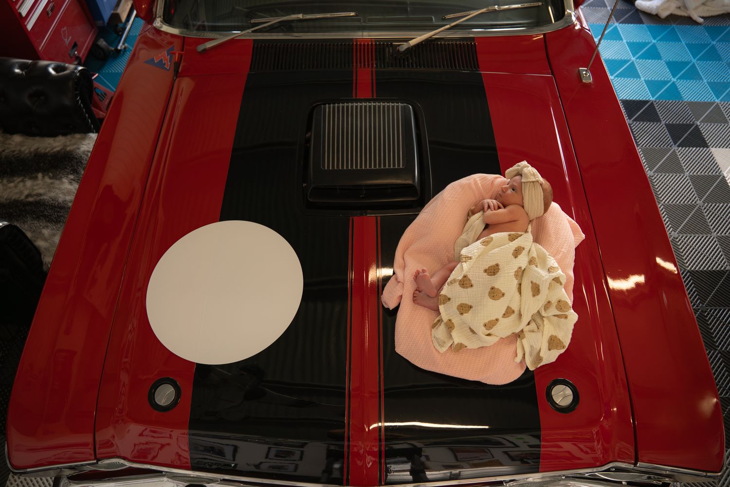 Newborn posed on top of race car bonnet during in home session — Photos by Bailey Rose Brisbane
