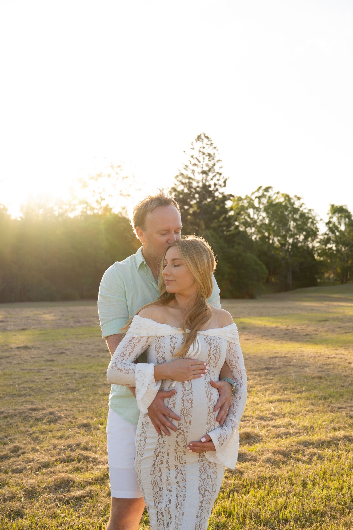 Expecting mother and father in white lace dress in open field — Photos by Bailey Rose Brisbane
