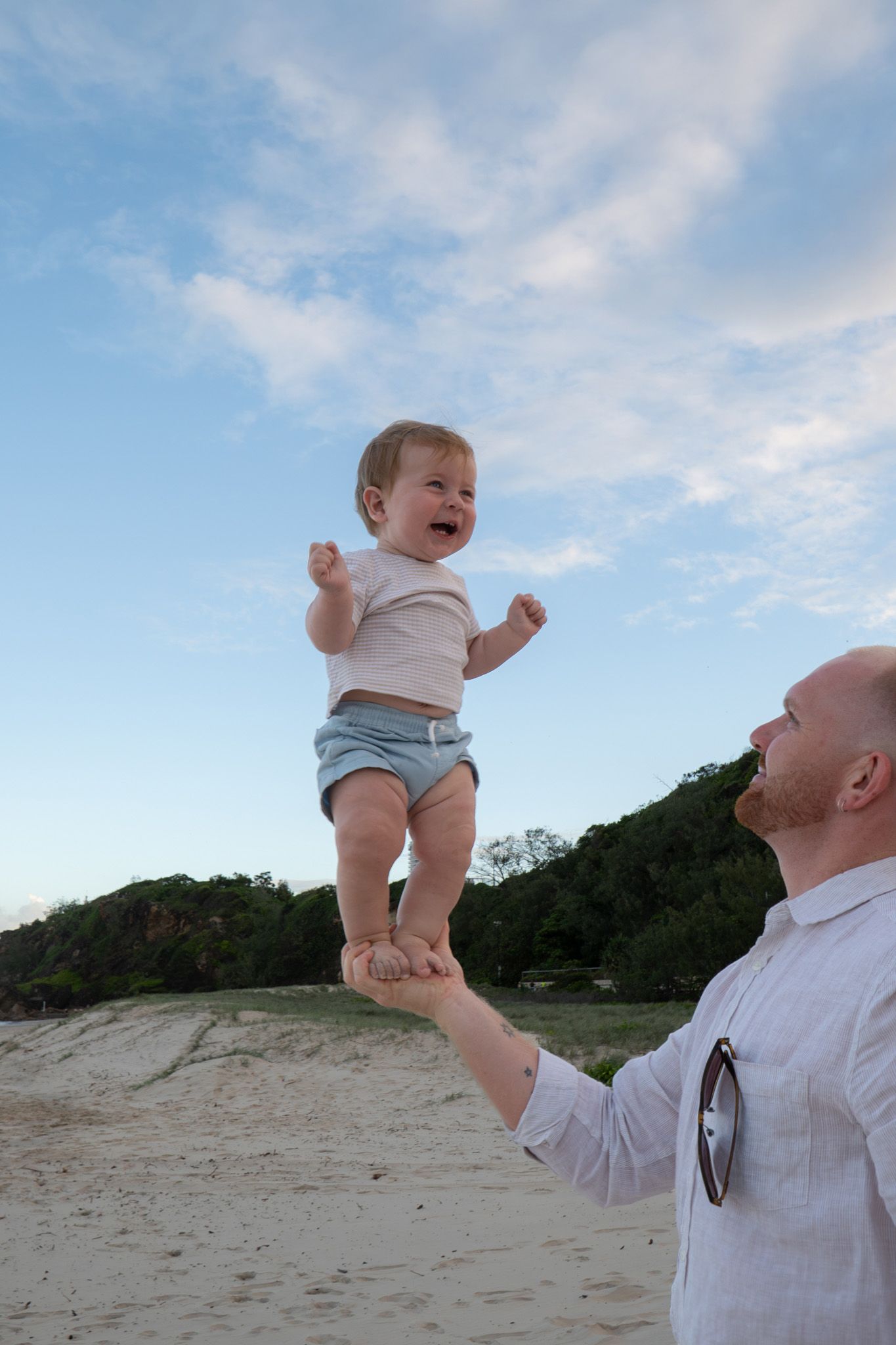Baby laughing thrown in the air by dad beach golden hour unposed family session - Photos by Bailey Rose Gold Coast