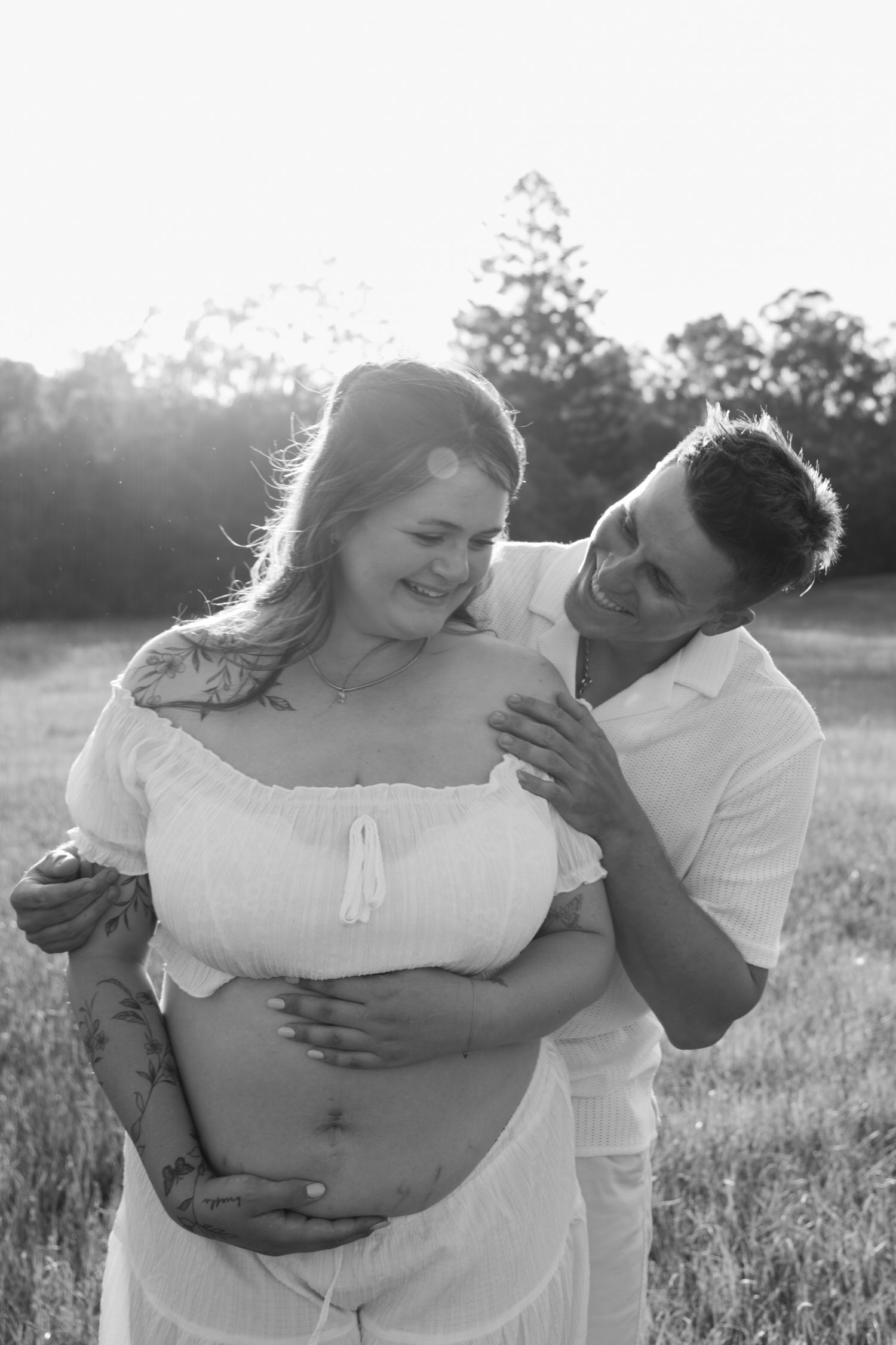 Couple laughing Maternity in black and white during golden hour in open field - Photos by Bailey Rose Gold Coast