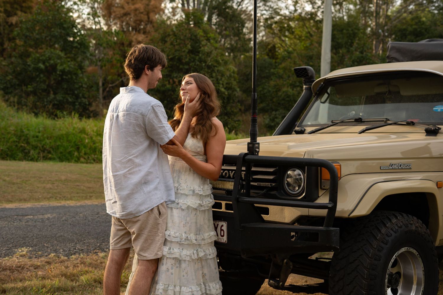 Couple sharing a natural loving moment in front of Land Cruiser 4WD in greenery at golden hour - Photos by Bailey Rose Gold Coast Brisbane