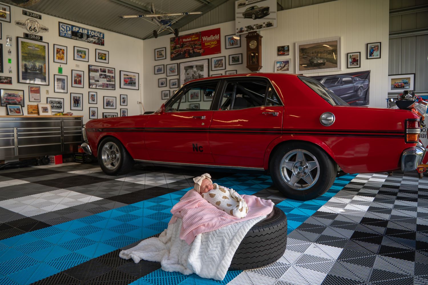 Newborn posed on top of race car tyre during in home session — Photos by Bailey Rose Brisbane