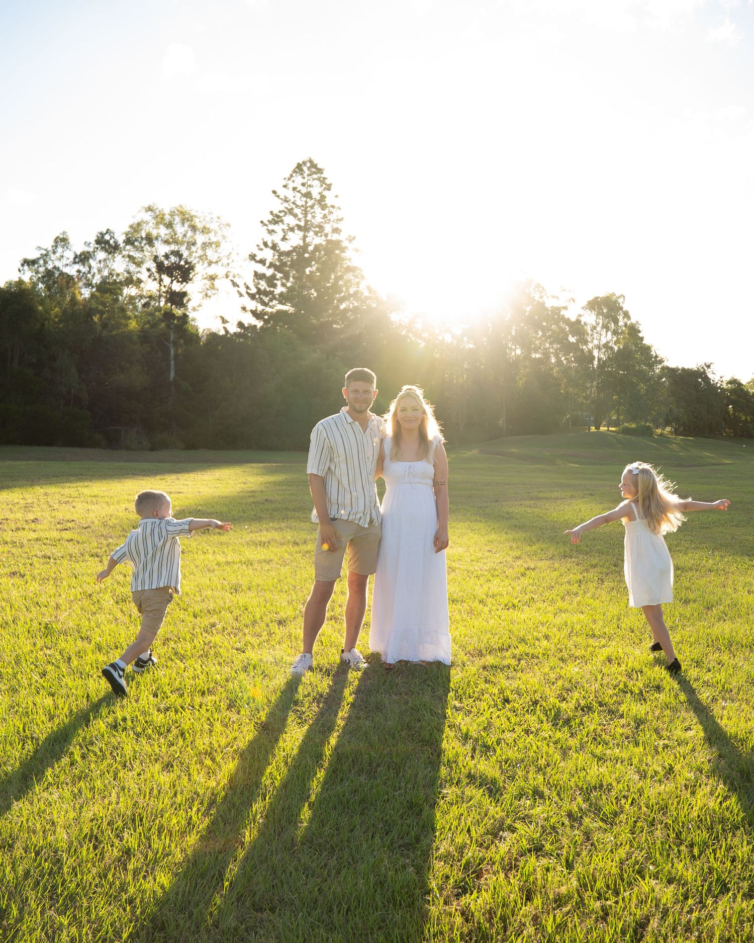 Children running around parents in open field at golden hour family session - Photos by Bailey Rose Gold Coast Brisbane