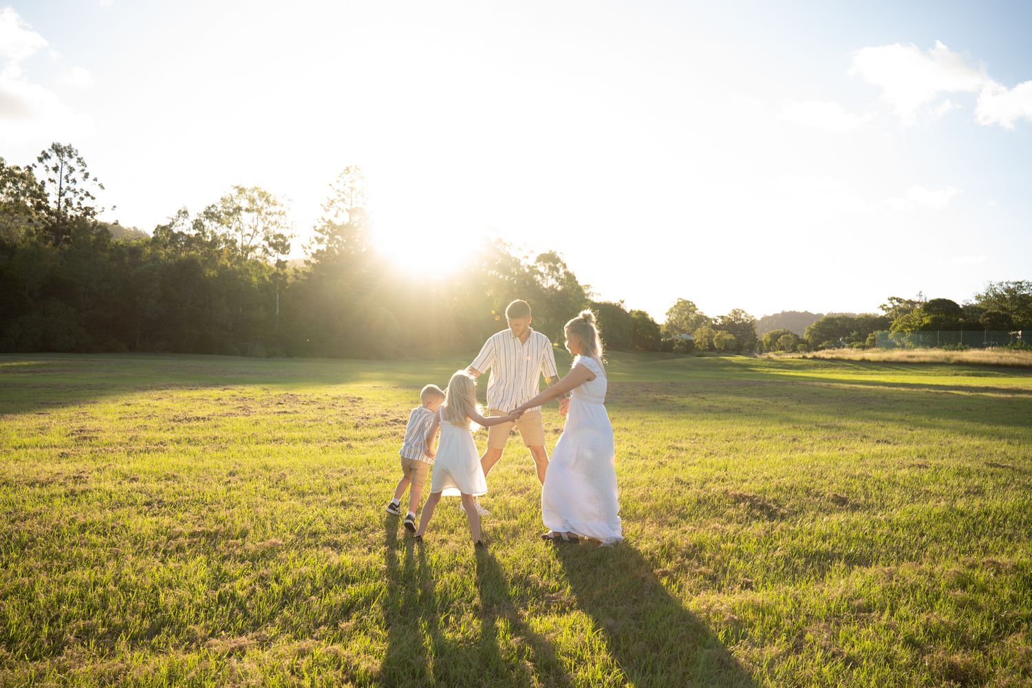 Family of four dancing together in an open field, unposed family portraits - Photos by Bailey Rose Gold Coast, Brisbane
