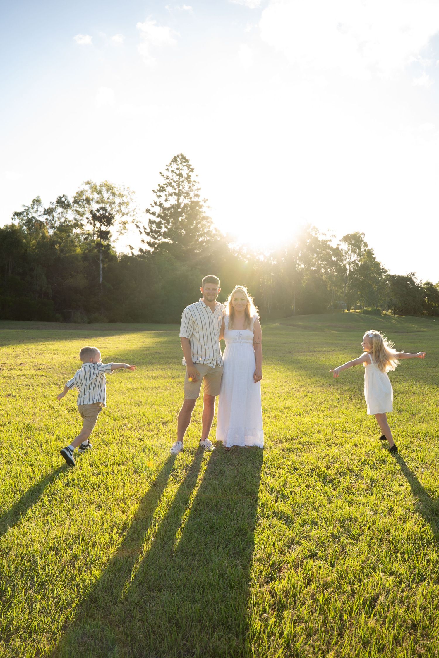 Children running around parents in open field at golden hour family session - Photos by Bailey Rose Gold Coast Brisbane