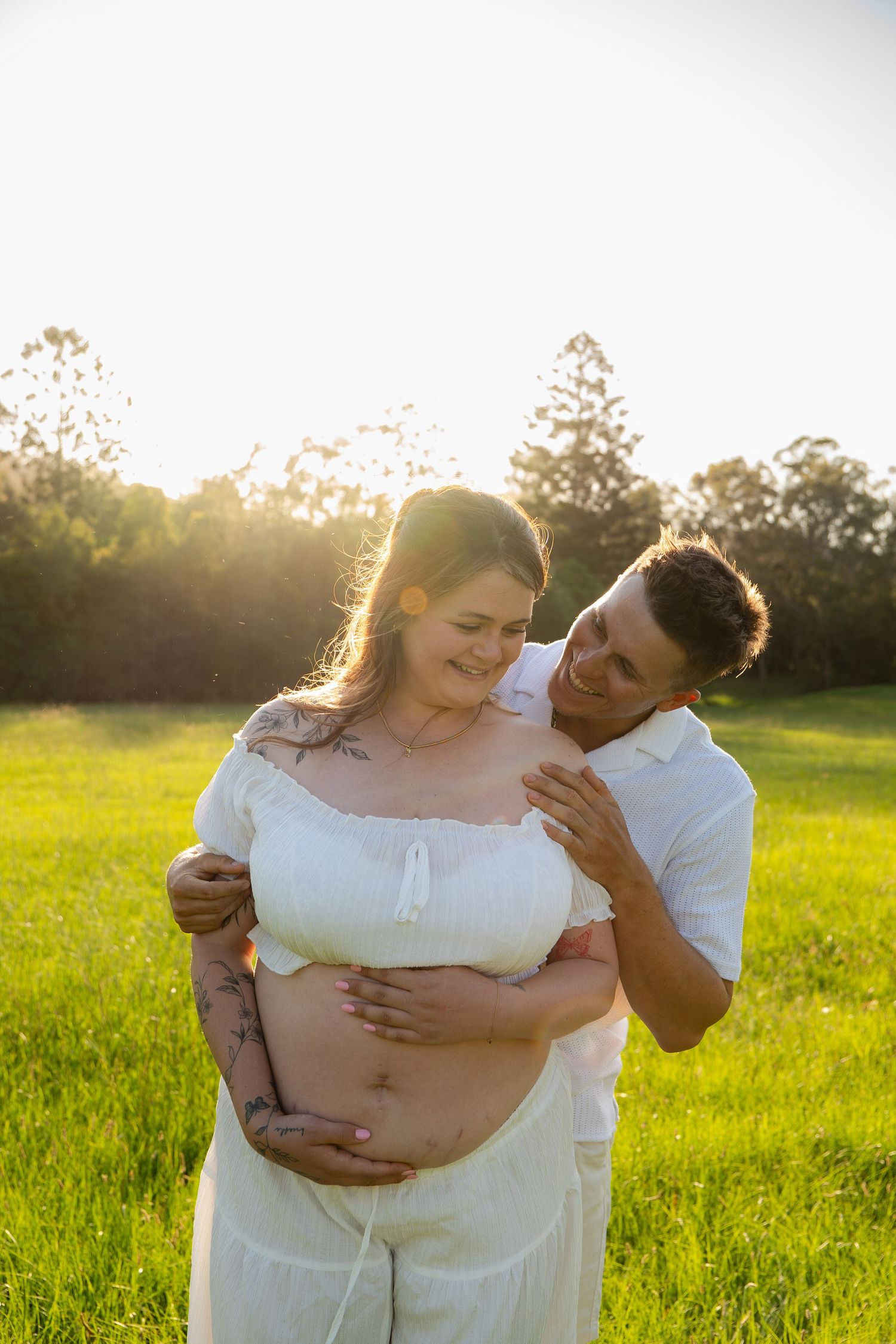 Couple laughing Maternity golden hour in open field - Photos by Bailey Rose Gold Coast