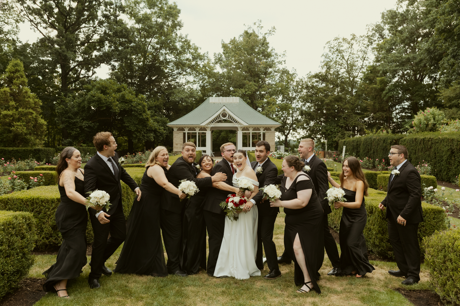 big wedding party all shares a laugh and embrace the bride and groom