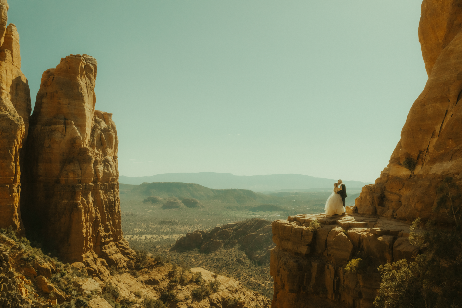 newly eloped couple shares a kiss at the top of Cathedral Rock in Sedona Arizona