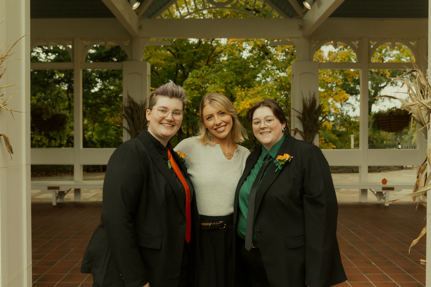 artistic, fun wedding photographer poses with newly married couple