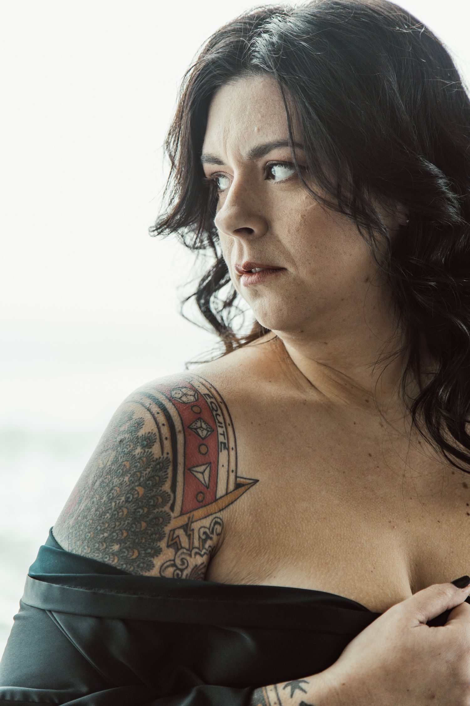 Intimate portrait series featuring shoulder tattoos and dark clothing against natural light.