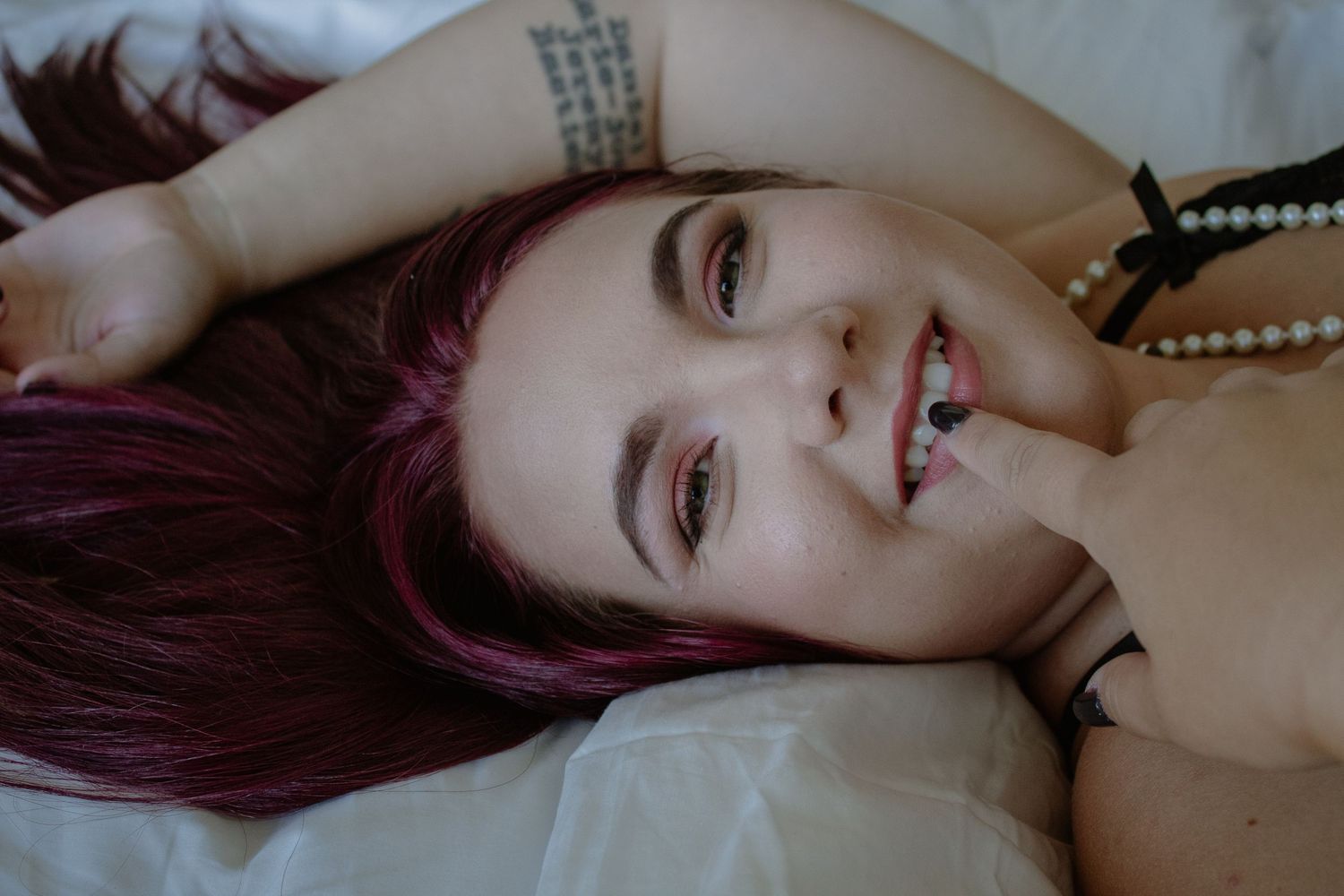 Artistic boudoir photo showing jewelry and soft lighting effects.