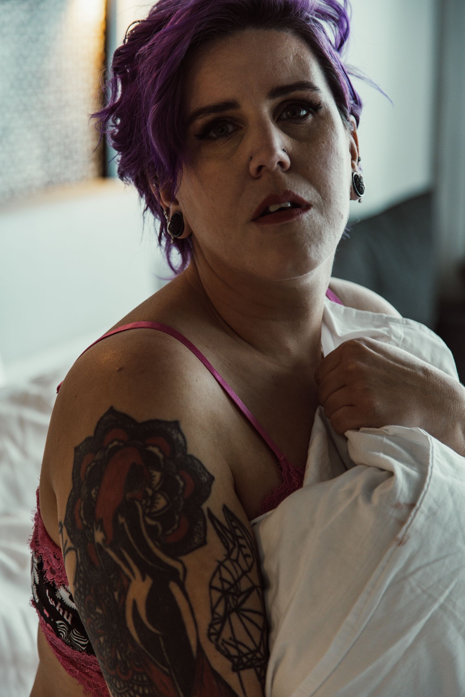 Intimate portrait showing detailed tattoo artwork and lingerie.