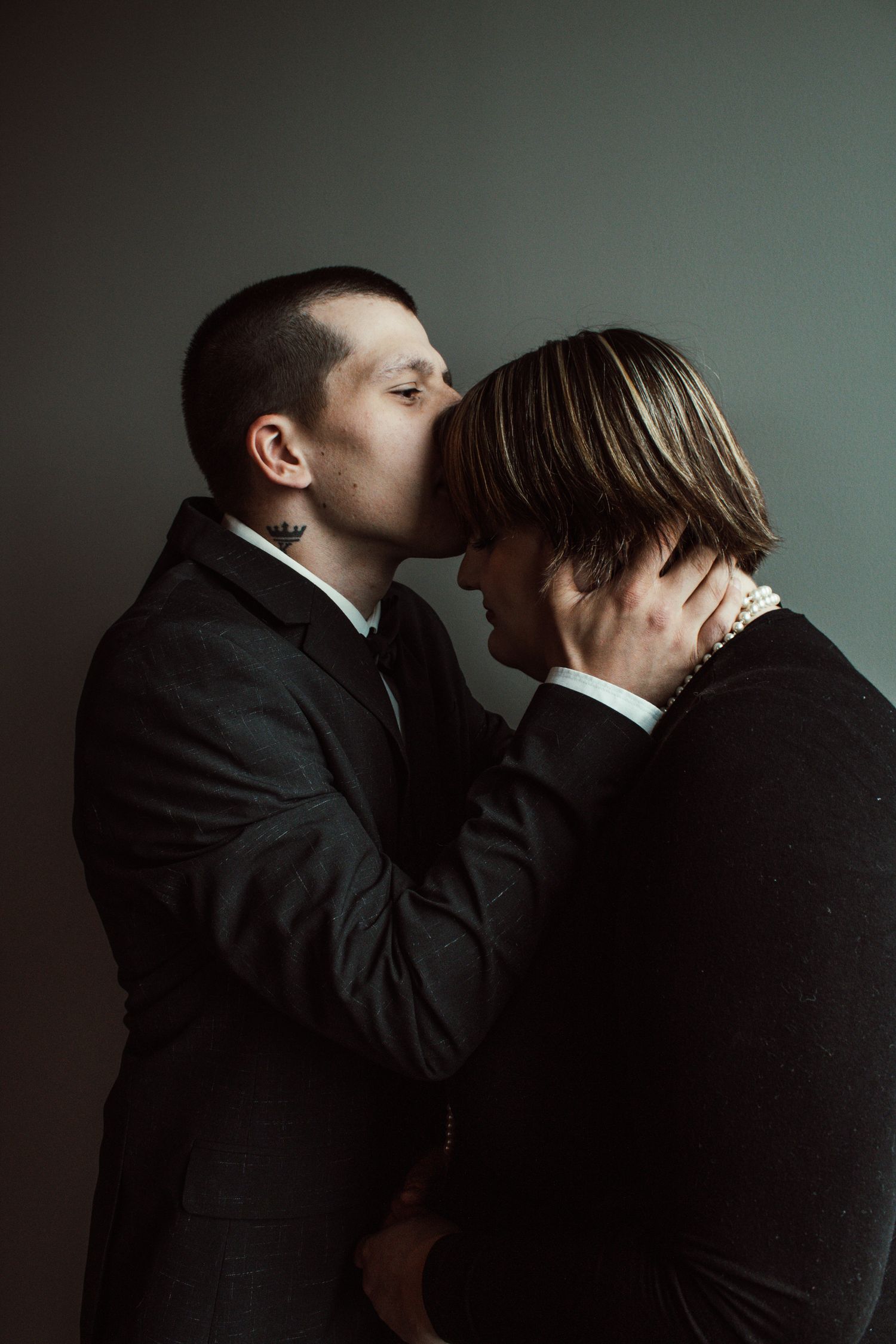 Dramatic portrait of couple in formal wear sharing intimate moment.