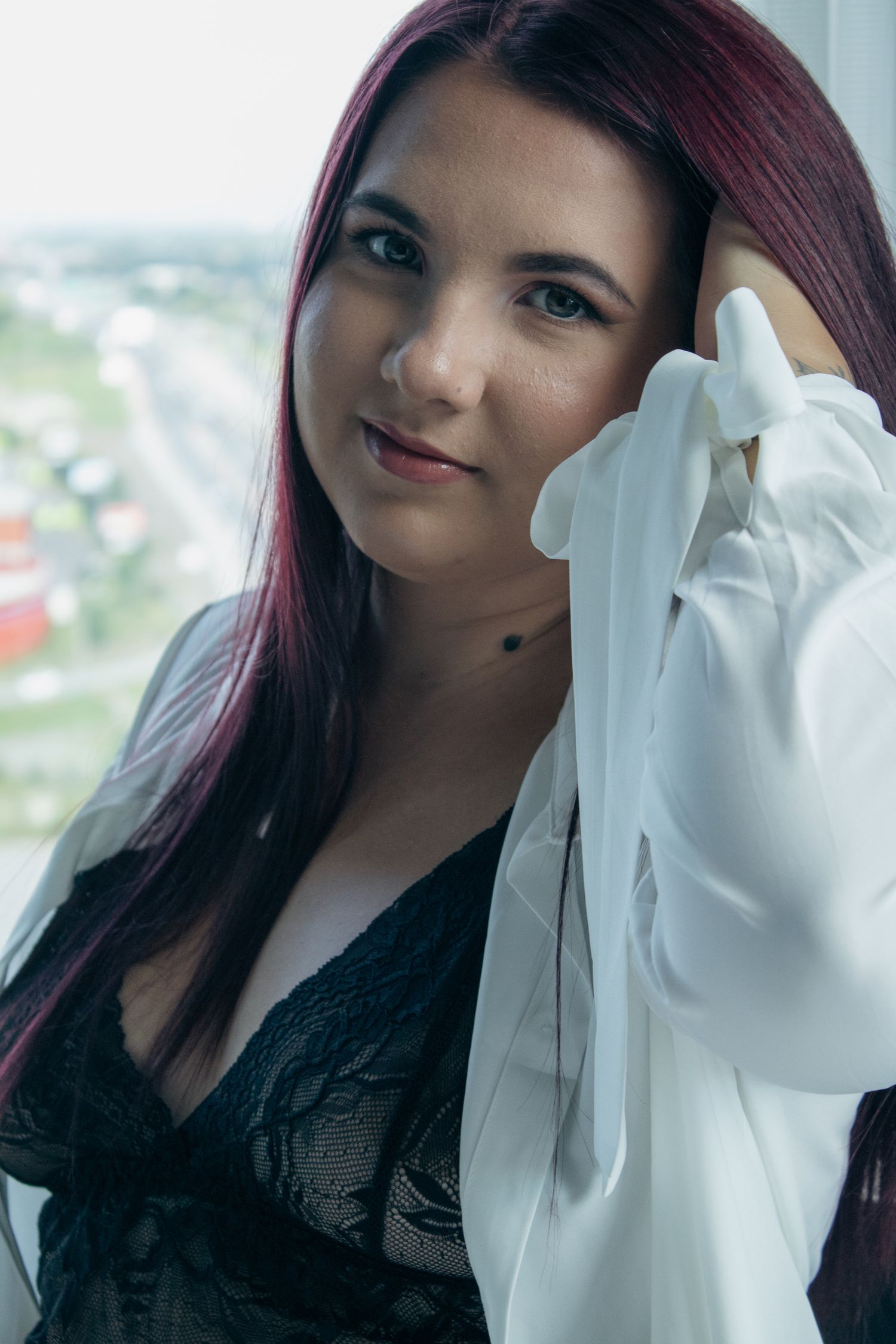 Figure in white gloves and black top poses against city backdrop.