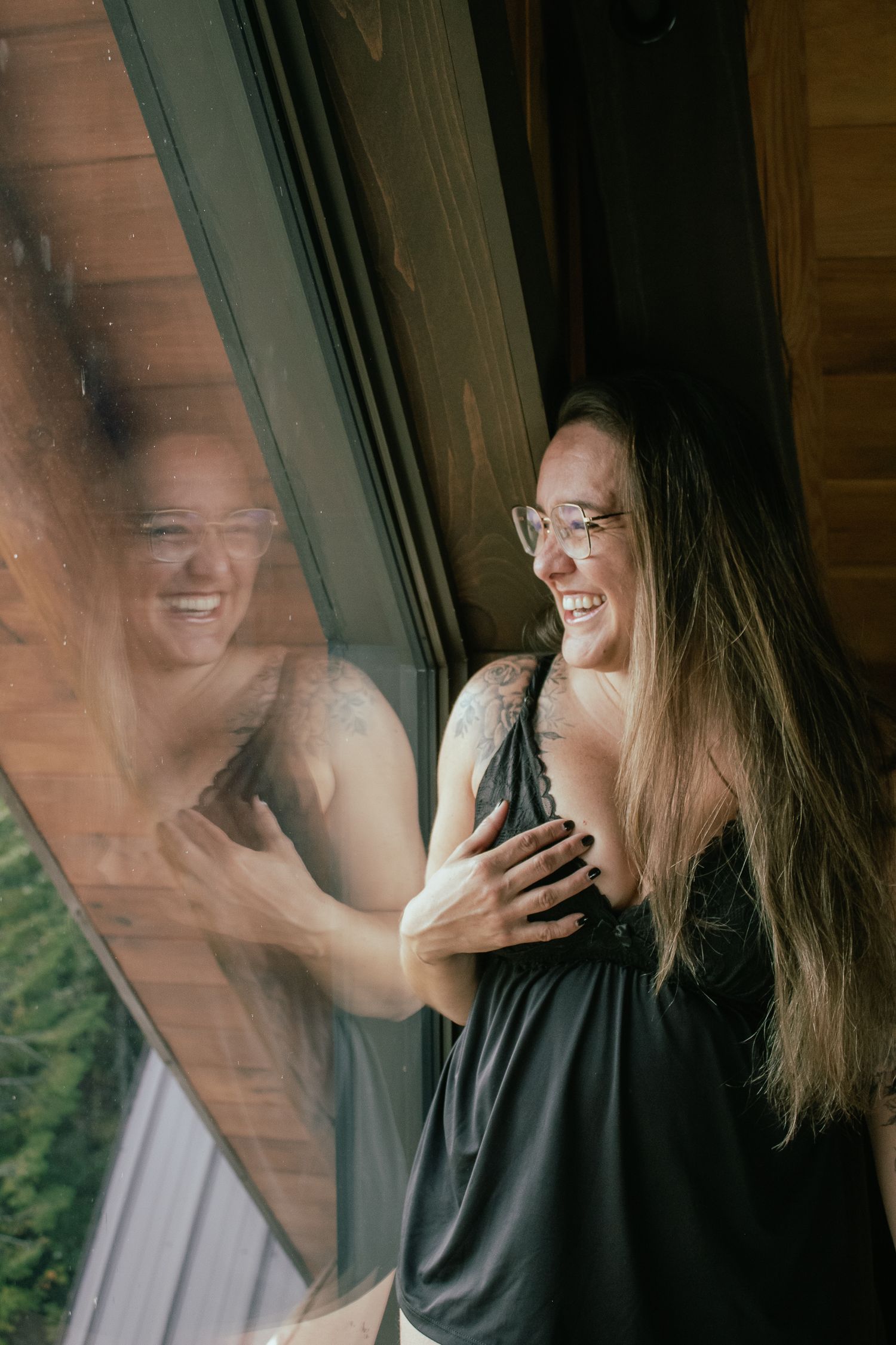 Candid laughing moments captured through window reflection.