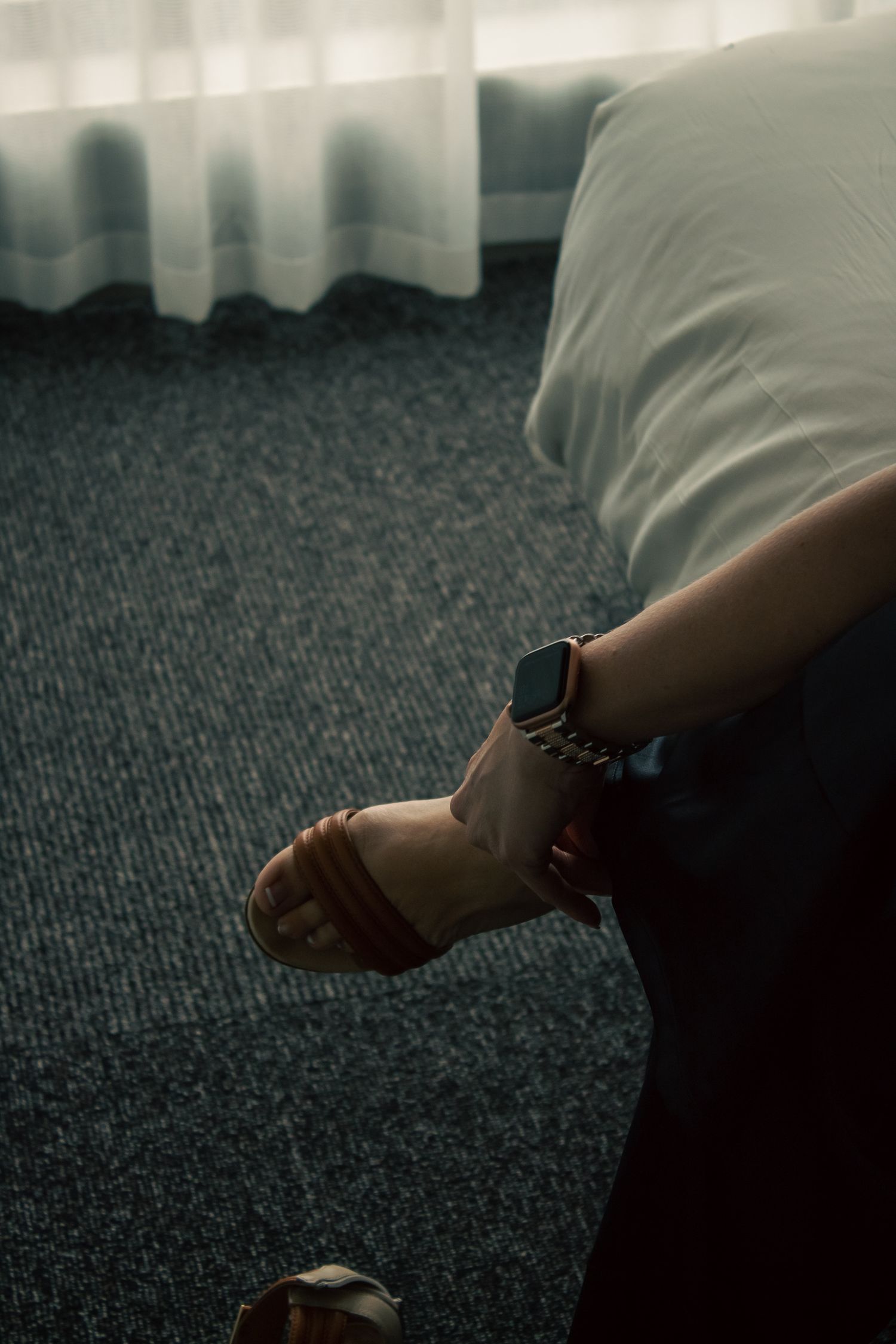 Close-up detail shots of feet against dark carpet with moody lighting.