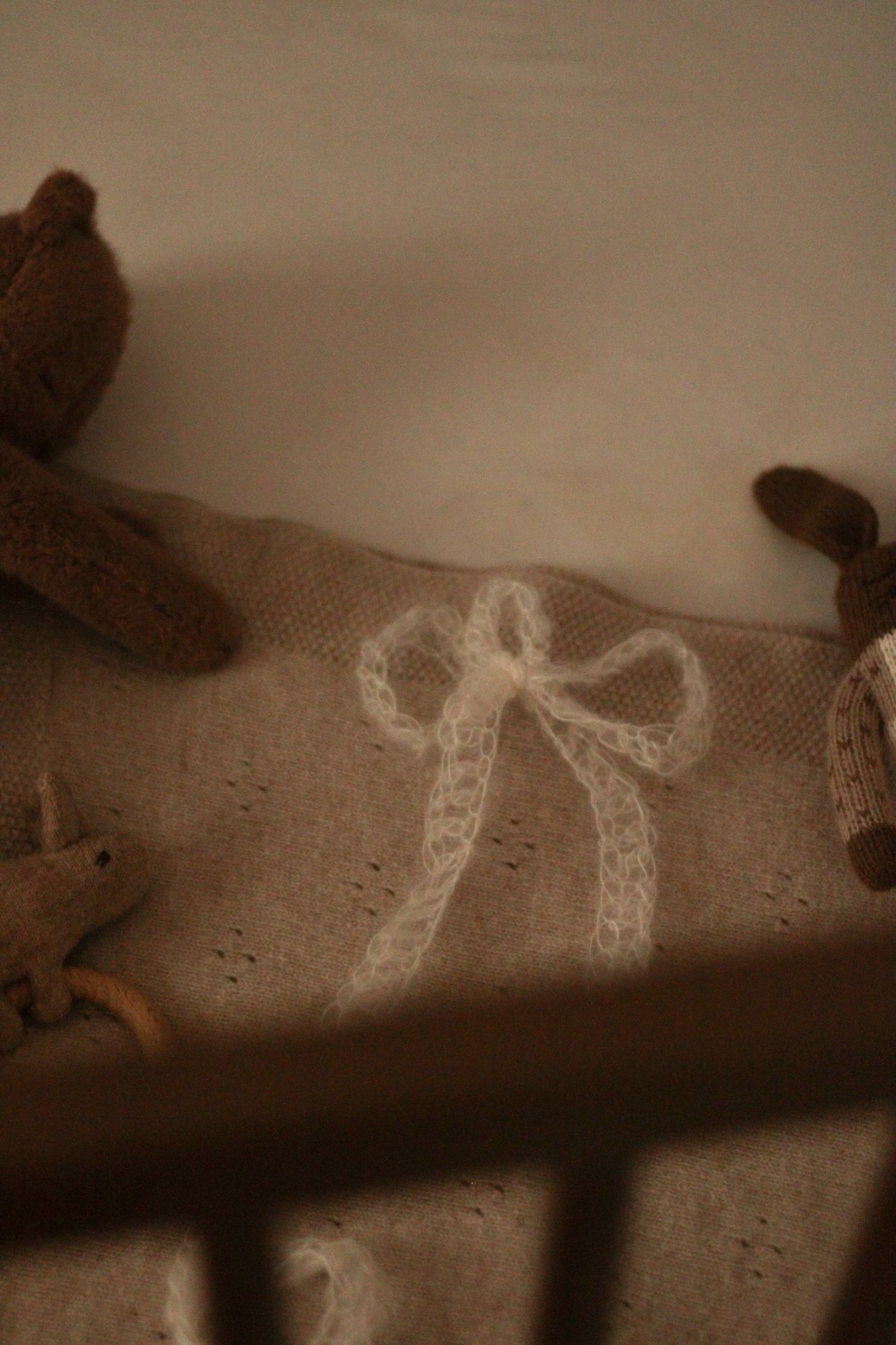Photo artistique à Montréal, détail de dentelle blanche délicate sur fond beige texturé, éclairage style vintage.